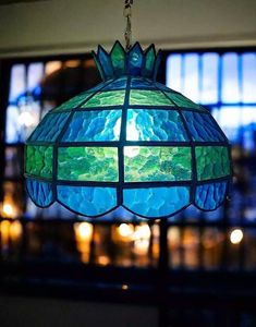 a blue and green lamp hanging from a ceiling