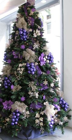 a decorated christmas tree with purple and gold decorations