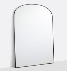 an arched mirror is shown against a white wall