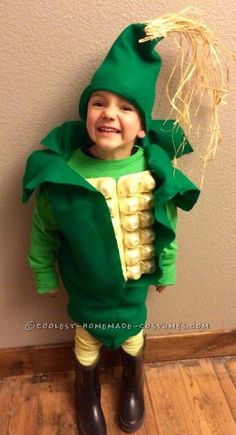 a little boy dressed up as a corn cob and wearing a green costume for halloween