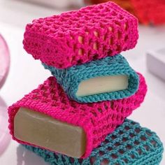 two soap bars stacked on top of each other in crochet patterns, one is pink and the other is blue