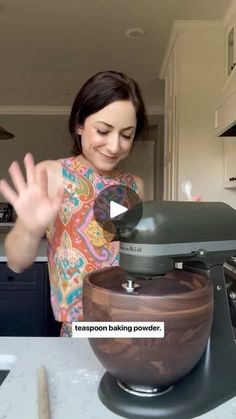 a woman standing in front of a mixer