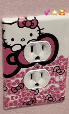 a hello kitty light switch cover with pink and white designs on it's side