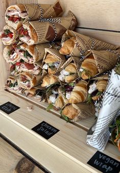 several sandwiches are stacked on top of each other with wrappers attached to the sides