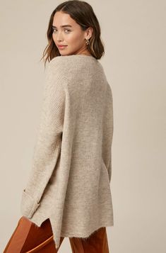 So chic and effortless, this slouchy, oversized tunic-style sweater features a v-neckline and dropped wide sleeves for added shape. -Available in Stone & Misty Blue -Waffle textured -V-neck -Oversized fit -Soft touch eyelash two tone yarn -Long sleeve with folded cuffs -Side slits -Ribbed on hem -Content: 74% Acrylic 22% Polyester 4% Lycra -Hand was cold/Line dry -Imported -Model is 5 8" 32-24-34 and wearing a size Small Oversized V-neck Sweater For Layering, Oversized Chic V-neck Sweater, Beige V-neck Sweater For Fall Loungewear, Oversized V-neck Sweater For Fall, Oversized V-neck Sweater For Loungewear, Chic Oversized V-neck Sweater For Loungewear, Oversized V-neck Chic Sweater, Casual Oversized V-neck Sweater For Loungewear, Oversized Chic Sweater With Ribbed Neckline