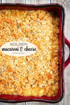 golden macaroni and cheese in a red casserole dish on a wooden table