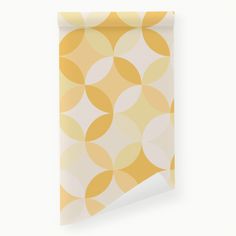 a yellow and white wallpaper with circles on it's side, next to a roll of paper