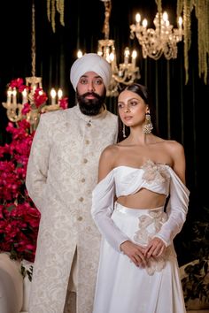 Perfect for the modern Indian bride, our VERONA White Velvet Lehenga Set checks off all the boxes. Made with luxurious velvet and adorned with shiny, embellished flowers, this set is a true beauty. Ethereal organza flowers are adorned with beads and sequins to add subtle sparkles to your special day. Elevate your look with this unique lehenga. This set includes a top and skirt only. SIZING Regardless of size chosen, we will reach out after your order is placed to confirm sizing via an in-person Fitted Floral Embellished Sets For Reception, Wedding Sherwani With Floral Embroidery In Traditional Drape, Wedding Sherwani With Floral Embroidery And Traditional Drape, Wedding Sherwani With Floral Embroidery, Glamorous Embroidered Wedding Sets, Luxury Lehenga With Resham Embroidery For Wedding, Luxury Wedding Lehenga With Resham Embroidery, Formal White Floor-length Lehenga, Designer White Sets With Floral Embroidery