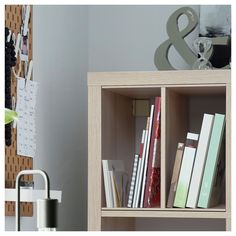 a book shelf with several books on it and a clock in the corner next to it