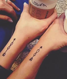 two people with matching tattoos on their arms and legs, holding coffee cups in their hands