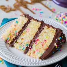 a slice of cake with chocolate frosting and sprinkles on a plate