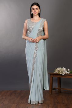 Shop a blue drape saree with embroidered blouse. Make a fashion statement on festive occasions and weddings with designer sarees, designer suits, Indian dresses, Anarkali suits, palazzo suits, designer gowns, sharara suits, and embroidered sarees from Pure Elegance Indian fashion store in the USA. Blue Dola Silk Pre-draped Saree For Reception, Diwali Mirror Work Pre-draped Saree, Embellished Blue Anarkali Pre-draped Saree, Diwali Sequined Chanderi Pre-draped Saree, Blue Embellished Saree For Eid, Blue Floor-length Pre-draped Saree With Mirror Work, Blue Sequined Pre-draped Saree, Blue Pre-draped Saree In Chanderi With Mirror Work, Blue Anarkali Chinon Pre-draped Saree