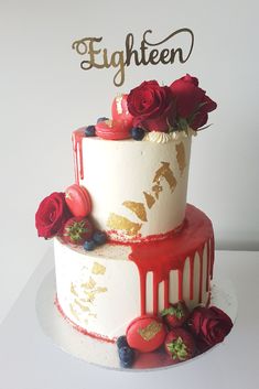 a three tiered cake with red and white frosting on top, decorated with roses