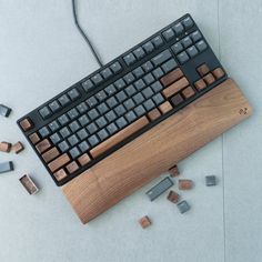 a computer keyboard with several pieces of wood on the ground next to it and some wires