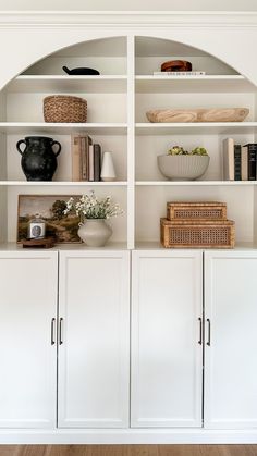 a white bookcase with many books and vases