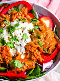 a bowl filled with meat and veggies on top of a bed of lettuce