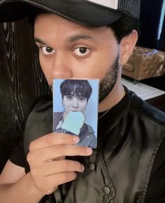 a man is holding up a polaroid with an image of him in the middle