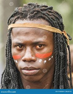 an african man with painted face and dreadlocks