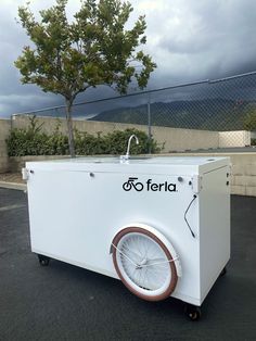 an ice cream cart with wheels parked in a parking lot