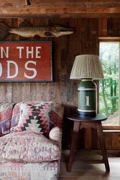 a living room filled with furniture and a wooden sign hanging on the wall above it