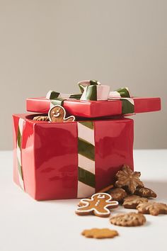 a red present box with gingerbreads and cookies on the floor next to it