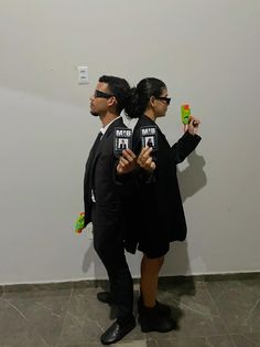 two people standing next to each other in front of a wall with magnets on it