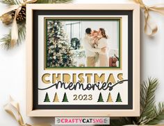 a christmas ornament with a couple kissing in front of a tree and pine cones