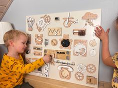 two children are playing with wooden toys on the wall