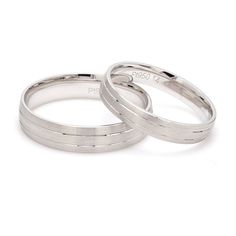 two white gold wedding rings on top of each other