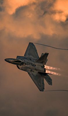 a fighter jet flying through a cloudy sky