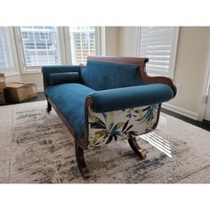 a blue couch sitting on top of a rug in a living room next to a window