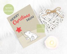 a christmas card with a polar bear holding a red star on it next to a candle