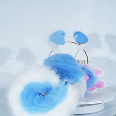 a blue and white stuffed animal sitting on top of a table next to a flower