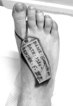 a black and white photo of a person's foot with a tag on it