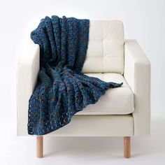 a white couch with a blue blanket on it