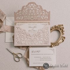 the wedding stationery is laid out on top of the table with scissors and ribbon