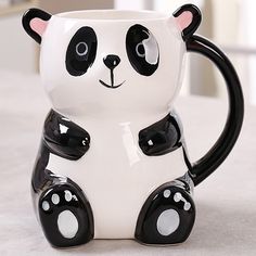 a black and white panda bear mug sitting on top of a table