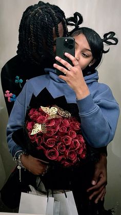 a woman taking a selfie with her cell phone while holding a bouquet of roses