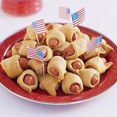 a plate full of hot dogs with american flags on them