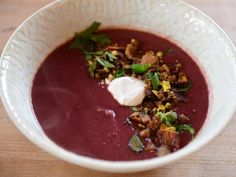 a white bowl filled with soup on top of a wooden table