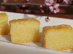 three pieces of cake sitting on top of a white plate with pink flowers in the background