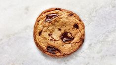 a chocolate chip cookie sitting on top of a white counter