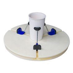 a white cup with blue handles on top of a plate that is connected to the base