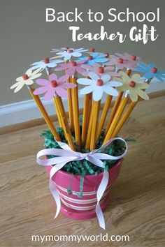 a pink flower pot filled with pencils on top of a wooden table