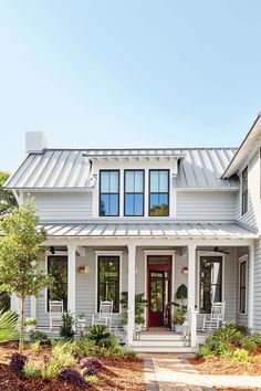 a white house with a metal roof and porch