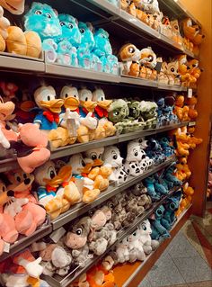 many stuffed animals are on shelves in a store