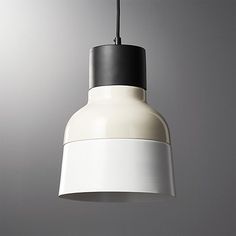 a white and black light hanging from a ceiling fixture in a room with gray walls