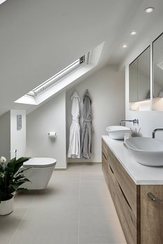 a white bathroom with two sinks and a bathtub in it's center area