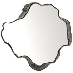 a mirror that is sitting on top of a white wall with an ornate design in the middle