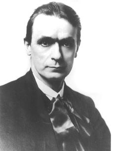 an old black and white photo of a man in a suit with a bow tie